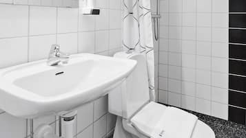 Un baño moderno con lavamanos, inodoro y ducha blancos.