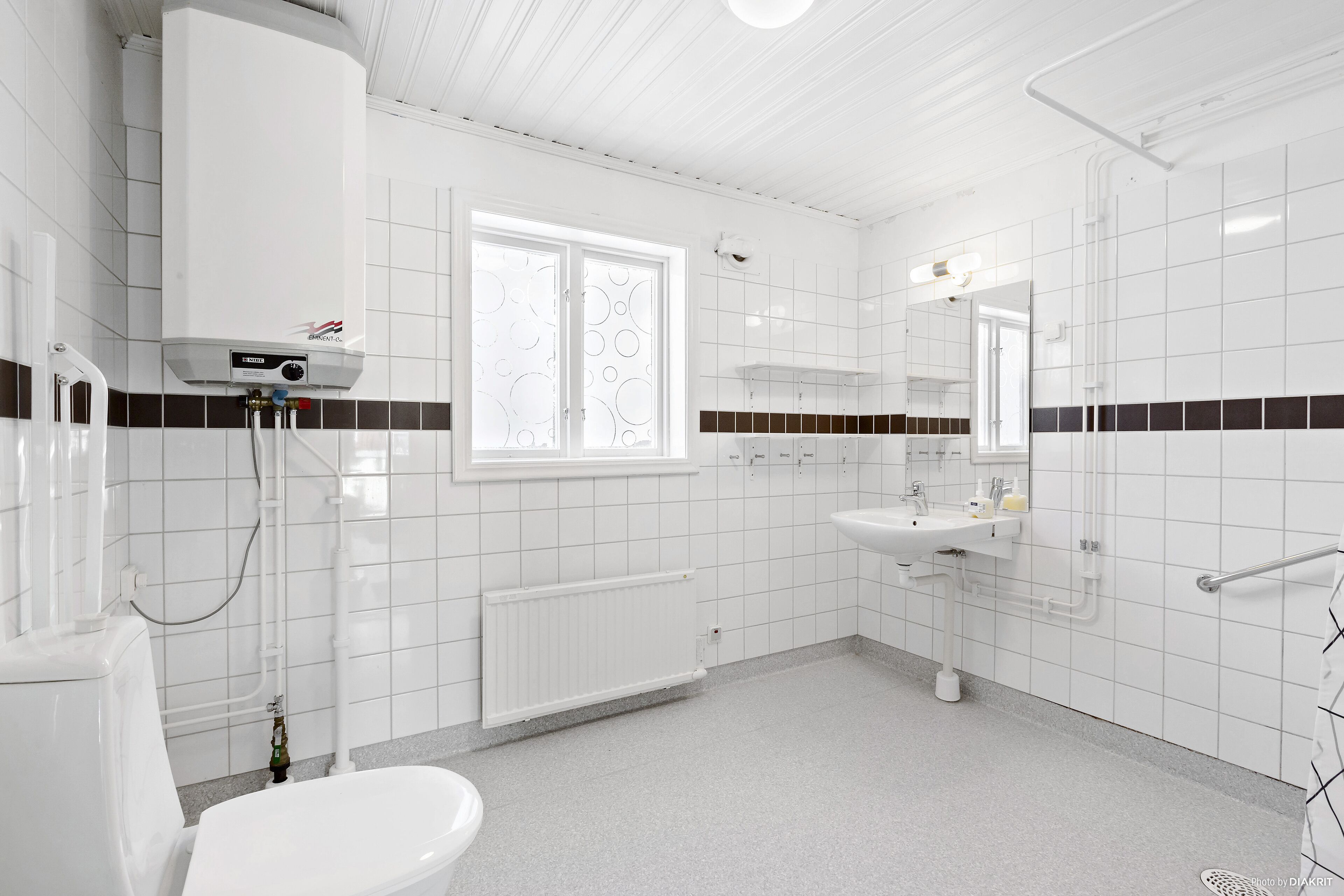 Une salle de bain moderne équipée de toilettes, d’un lavabo et d’une douche.