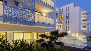 Een modern gebouw met balkons, grote ramen en een decoratieve gevel.