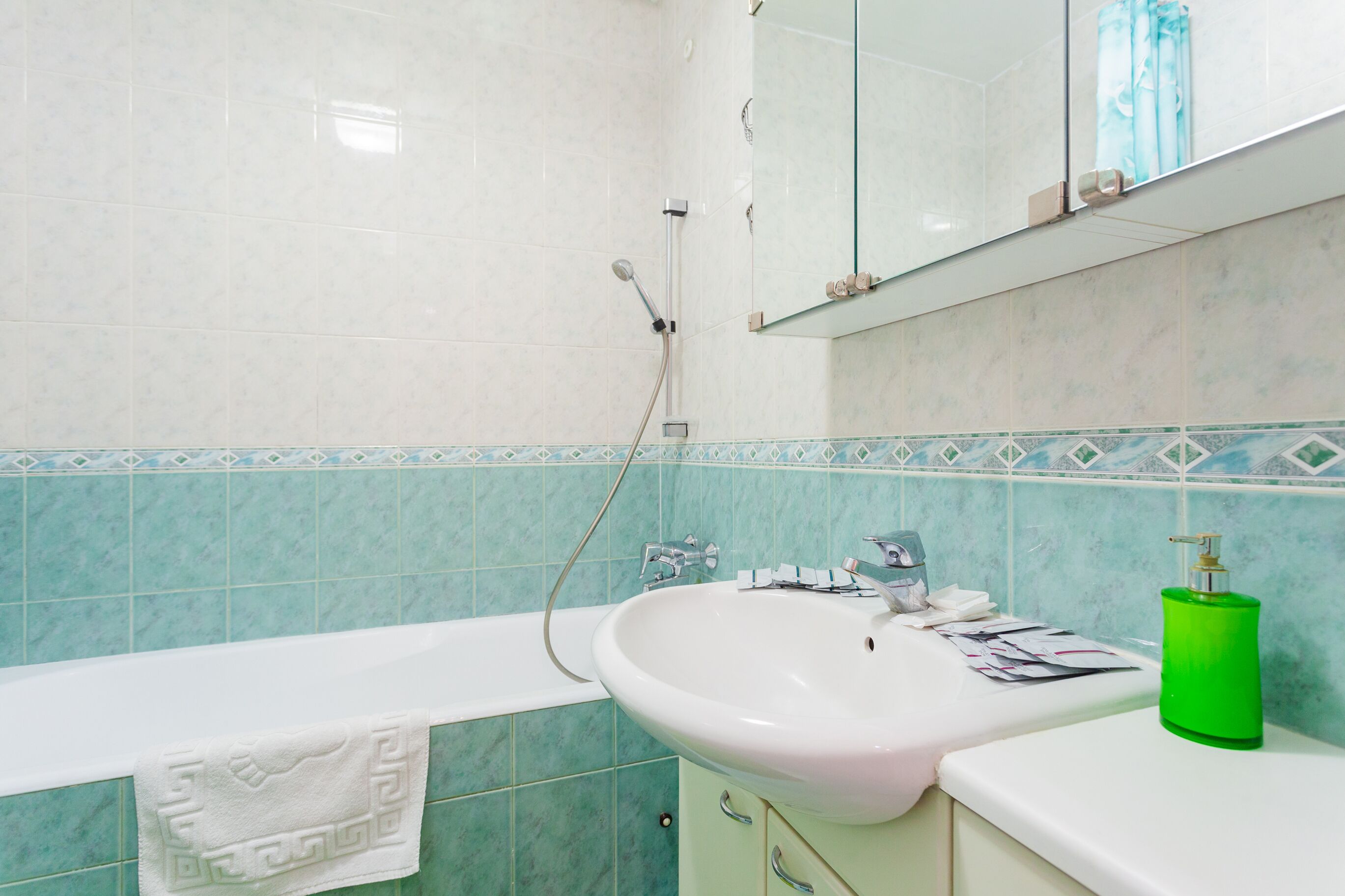 Une salle de bain avec une baignoire, un lavabo et un miroir.