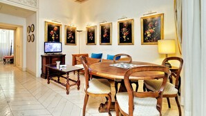 A dining area with a wooden table, chairs, and a television.