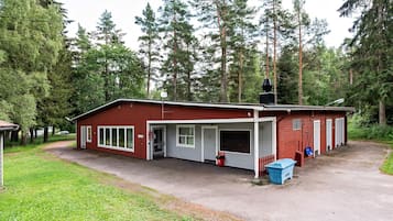 Ein rotes Gebäude mit Garage, überdachter Veranda und kleinem Vorgarten.