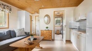 Une cuisine moderne avec des meubles blancs, un plan de travail en bois et un évier. On y trouve également un coin repas avec une table en bois et un canapé.