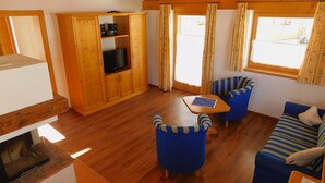 Chalet básico, 2 habitaciones | Sala de estar | Una televisión de pantalla plana, una chimenea, suelo radiante