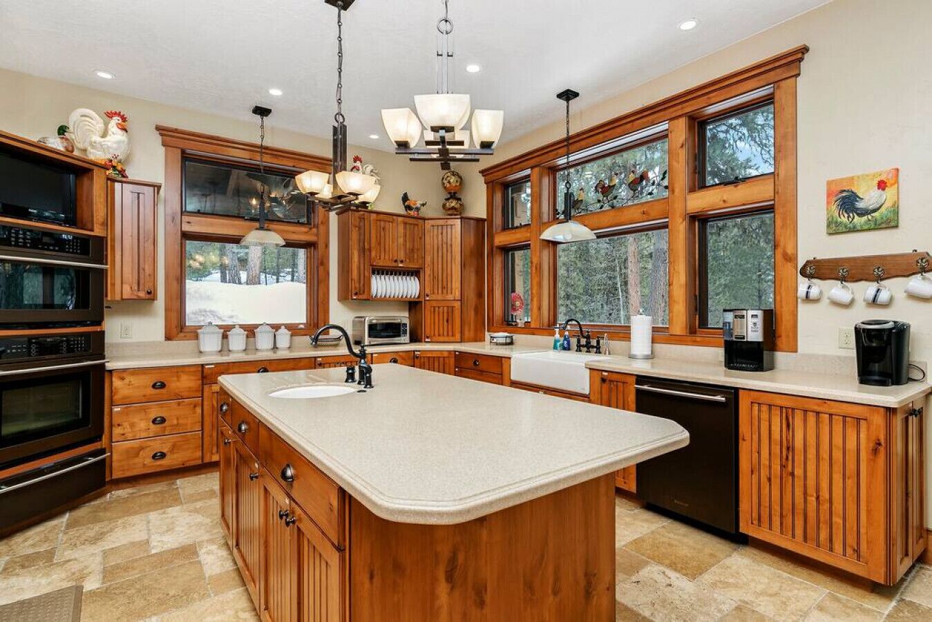 Une cuisine spacieuse avec des meubles en bois, un grand îlot central et une vue sur l’extérieur.