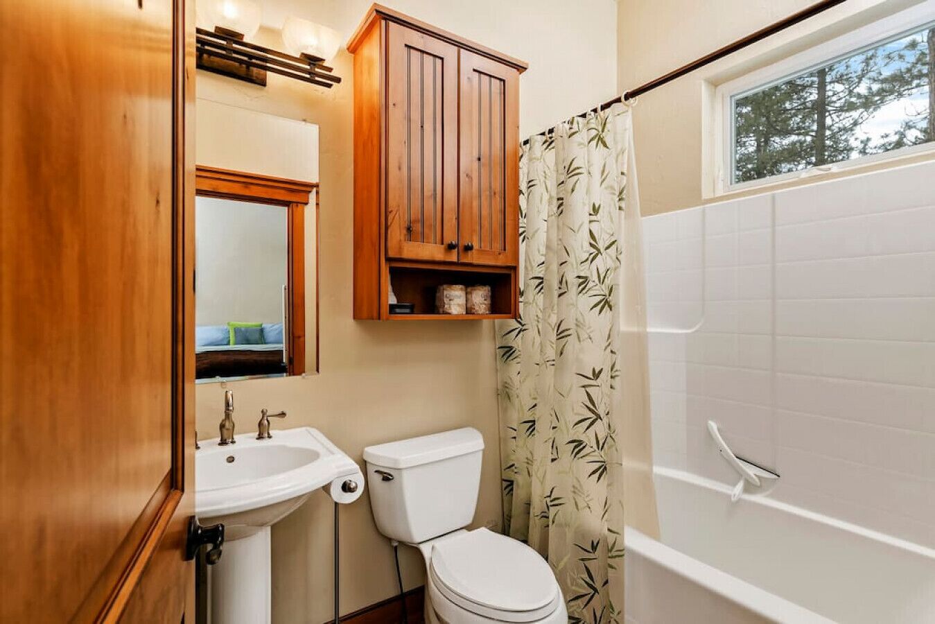 Ein Badezimmer mit Holzausstattung über dem Waschbecken, einer Toilette und einer Badewanne.