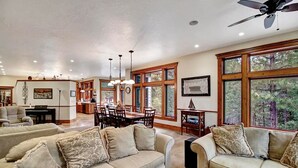 A spacious living room with a large sofa set, a dining area with a wooden table and chairs, and large windows offering a view of the outdoors. - Smiths Ferry Cabin by Cabarton & Snowmobile Trails (Smiths Ferry)