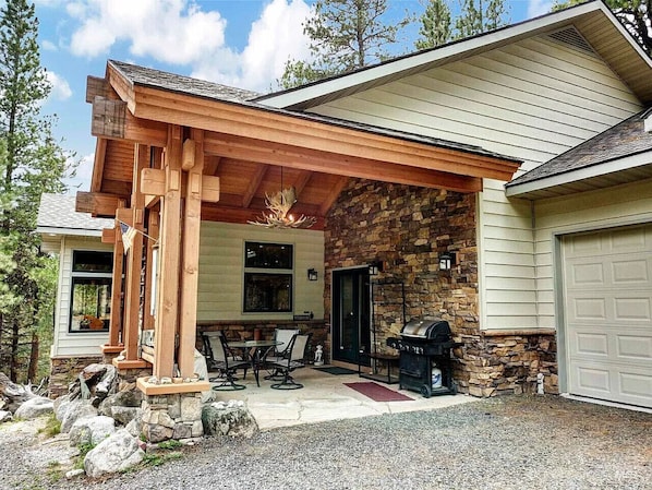 A covered patio with outdoor seating and a barbecue grill.