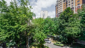 Un immeuble à plusieurs étages doté de balcons, entouré d’arbres verdoyants.