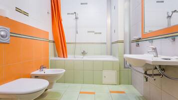 Une salle de bain avec une baignoire, deux lavabos et une douche.