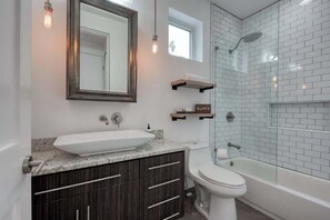 Bañera con ducha, secador de pelo, shampoo