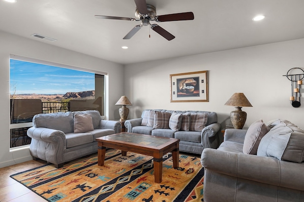 Relax in this inviting living room with a stunning desert view, featuring two sofas and a coffee table.