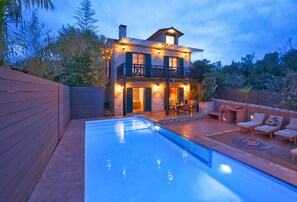 Vista frontal de la propiedad por la tarde o noche