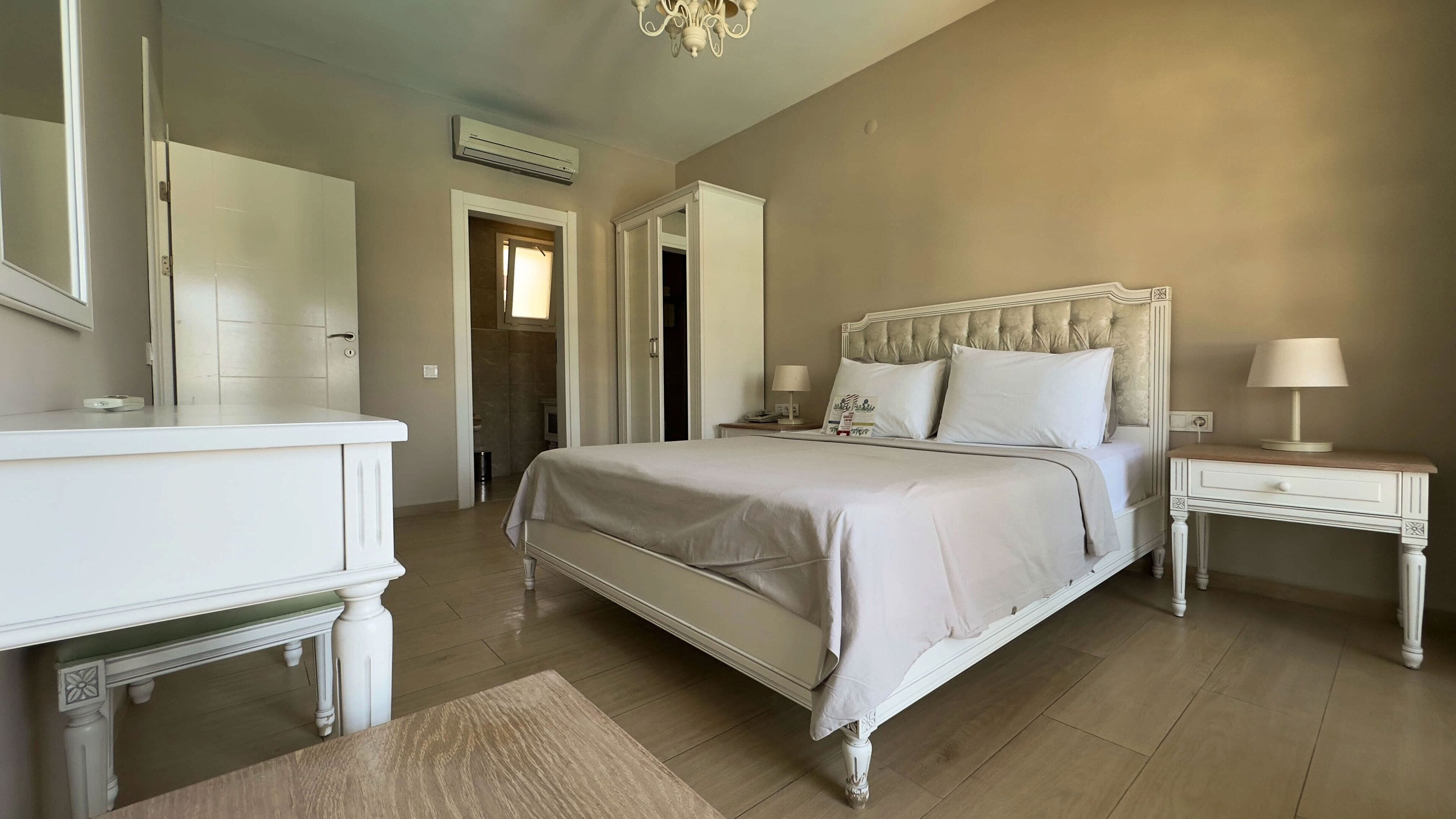 Una camera da letto con un letto, comodini, una cassettiera e uno specchio.