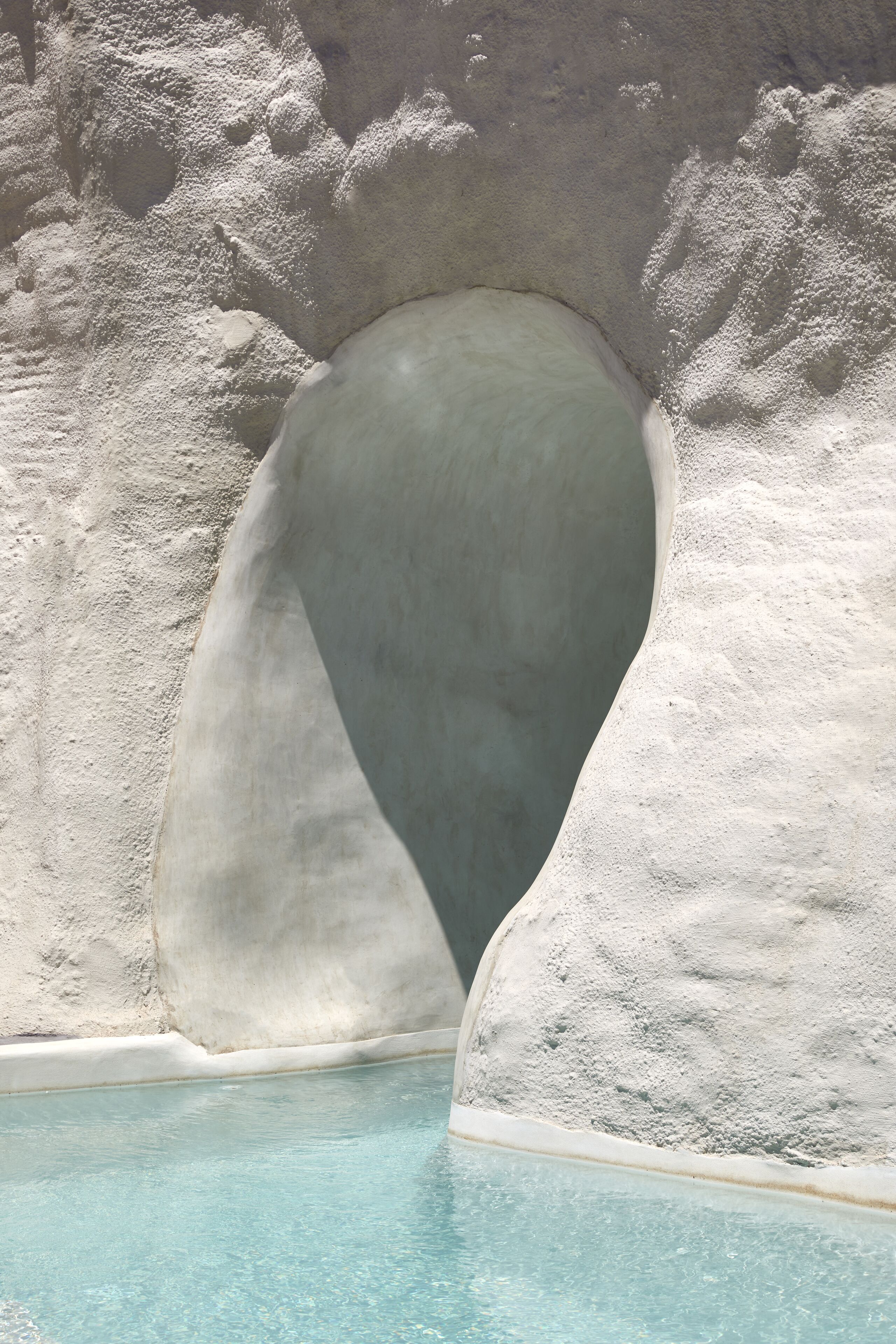 A swimming pool with a unique arched entrance.