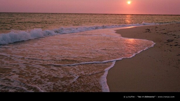 A beach at sunset with waves gently lapping the shore. - Eden Beach Saint-Louis (St. Louis)