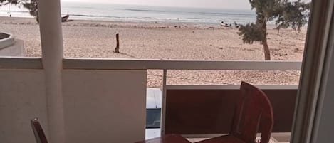 A balcony with a view of a beach and ocean.