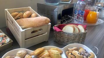 Ein reichhaltiges Frühstücksbuffet mit verschiedenen Brotsorten, Gebäck und Getränken.