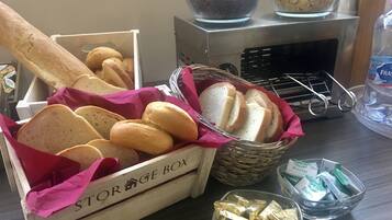 A storage box labeled "STORAGE BOX" containing bread, a basket with bread, and a bowl with chocolate bars.
