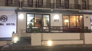 Ein Hotel mit weißer Fassade, mehreren Balkonen und einem Schild mit der Aufschrift "KH HOTEL".
