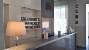 Ein Empfangstresen mit einer Lampe, einer Schlüsselanhänger-Ausstellung und einem Logo an der Wand.