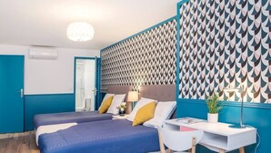 A hotel room with two beds, a desk, and a chair. - Elegant, Air-conditioned & Central, close Marais (Paris)