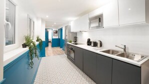 A modern kitchen with white cabinets, stainless steel appliances, and a grey countertop. - Elegant, Air-conditioned & Central, close Marais (Paris)