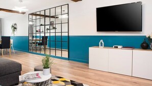 A modern office space with a large TV, a glass partition, and a white cabinet. - Elegant, Air-conditioned & Central, close Marais (Paris)