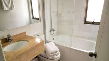 A bathroom with a sink, toilet, and bathtub.