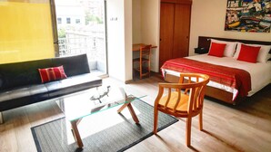 Una camera d'albergo con un letto, una poltrona, un tavolo da pranzo e una sedia.