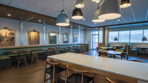 A modern restaurant with a central bar area, booths, and individual tables. - Fairfield Inn & Suites Duncan (Duncan)