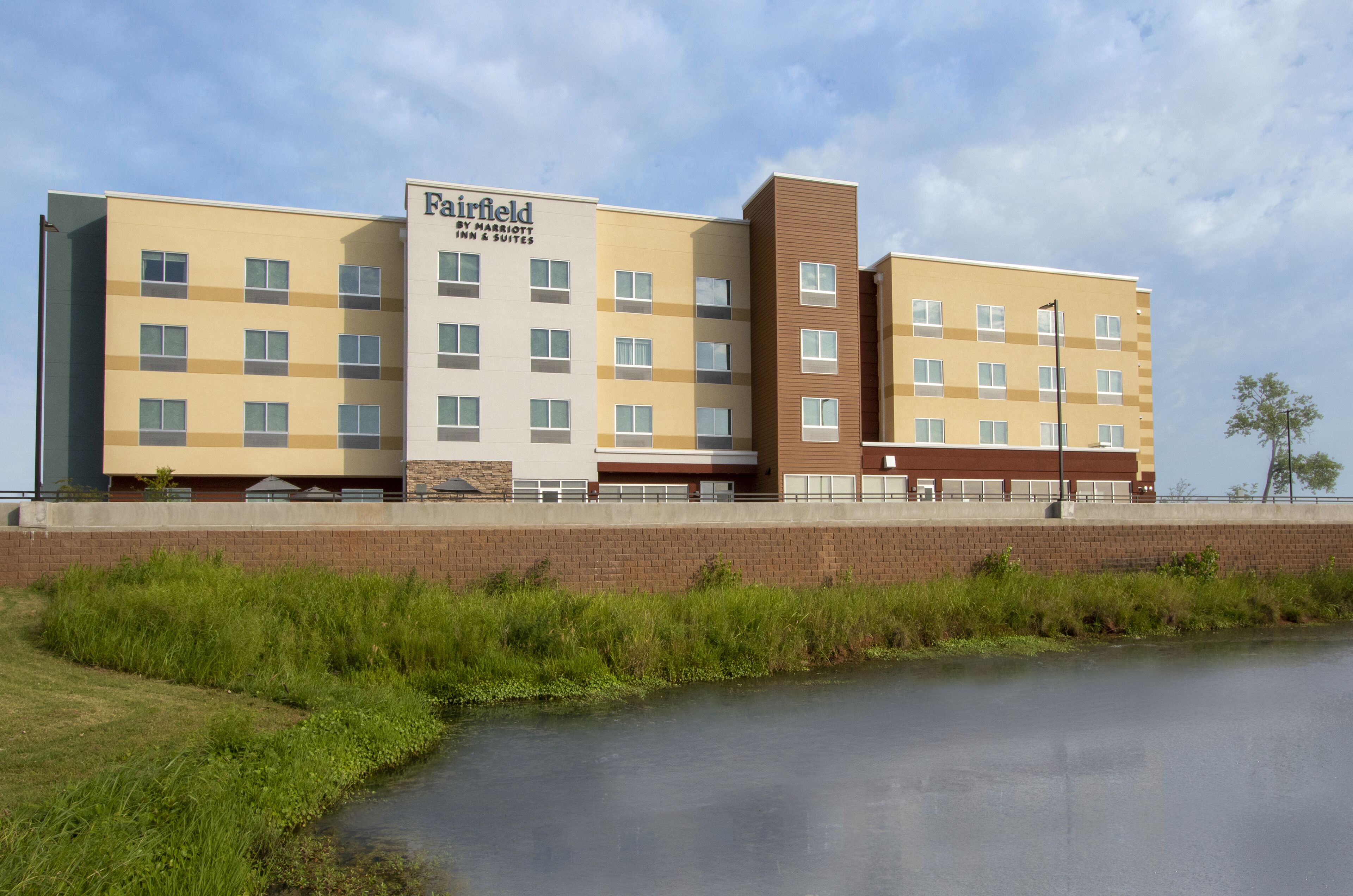 A multi-story hotel with a flat facade, multiple windows, and a sign indicating it is a Fairfield Inn & Suites.