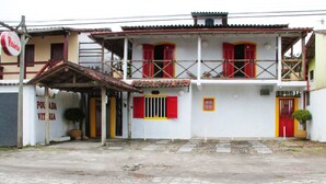 A two-story building with a balcony, red shutters, and a tiled roof. - Pousada Florescer (Paraty)