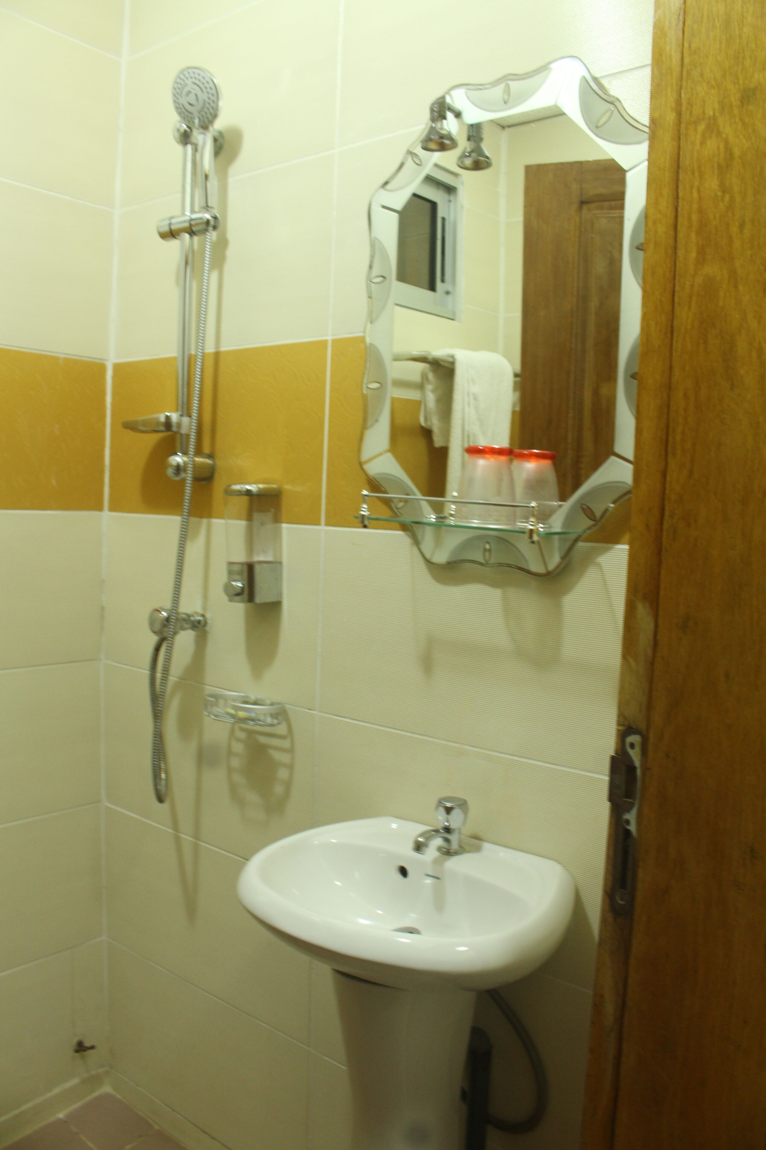 A bathroom with a shower, a sink, and a mirror.