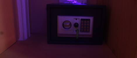 A small, dark room with a framed object on a shelf, possibly a safe or a decorative item.