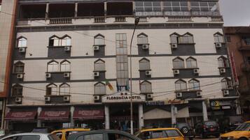 Un hotel con varios pisos, balcones y unidades de aire acondicionado.