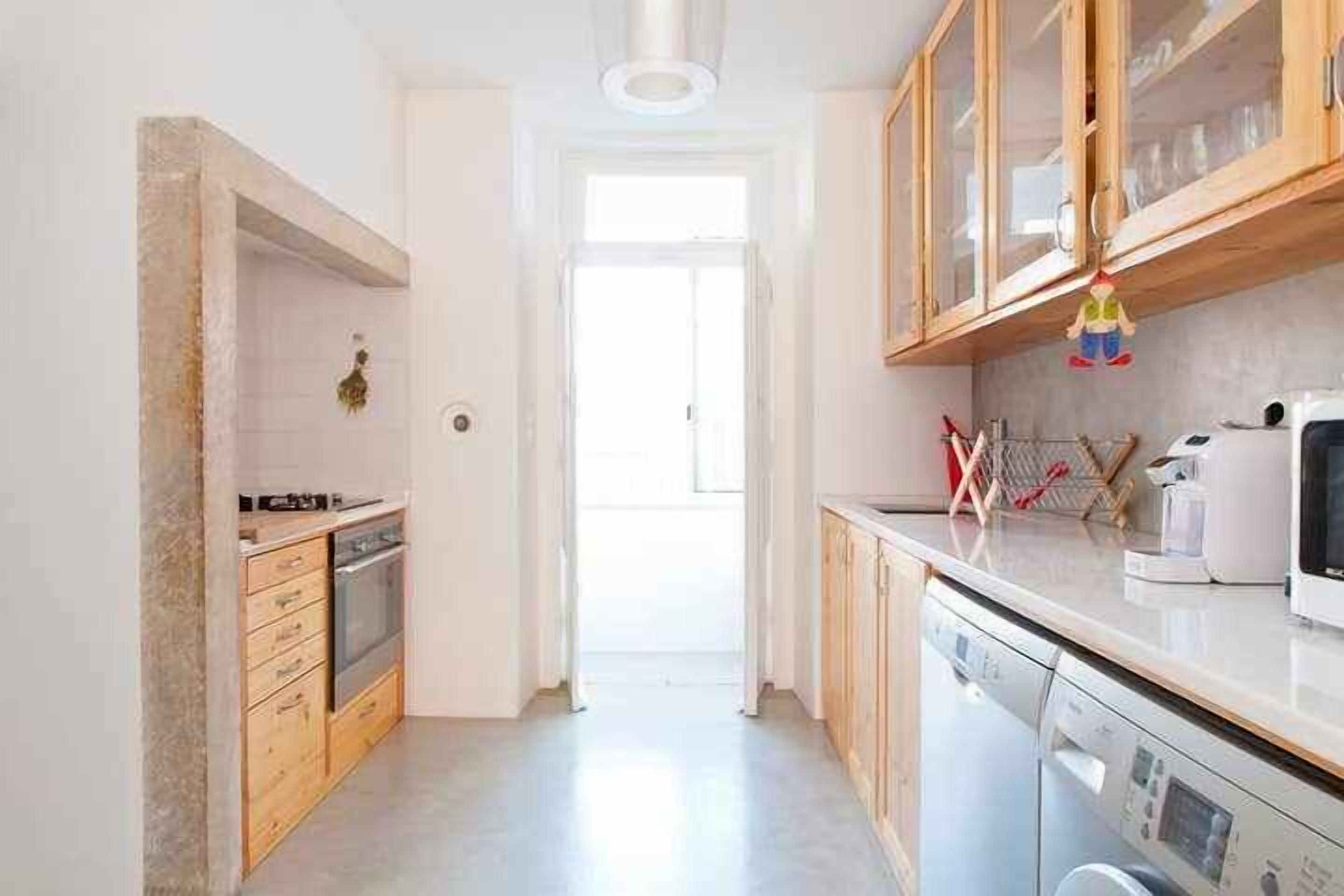 A modern kitchen with wooden cabinets, a dishwasher, and a microwave.