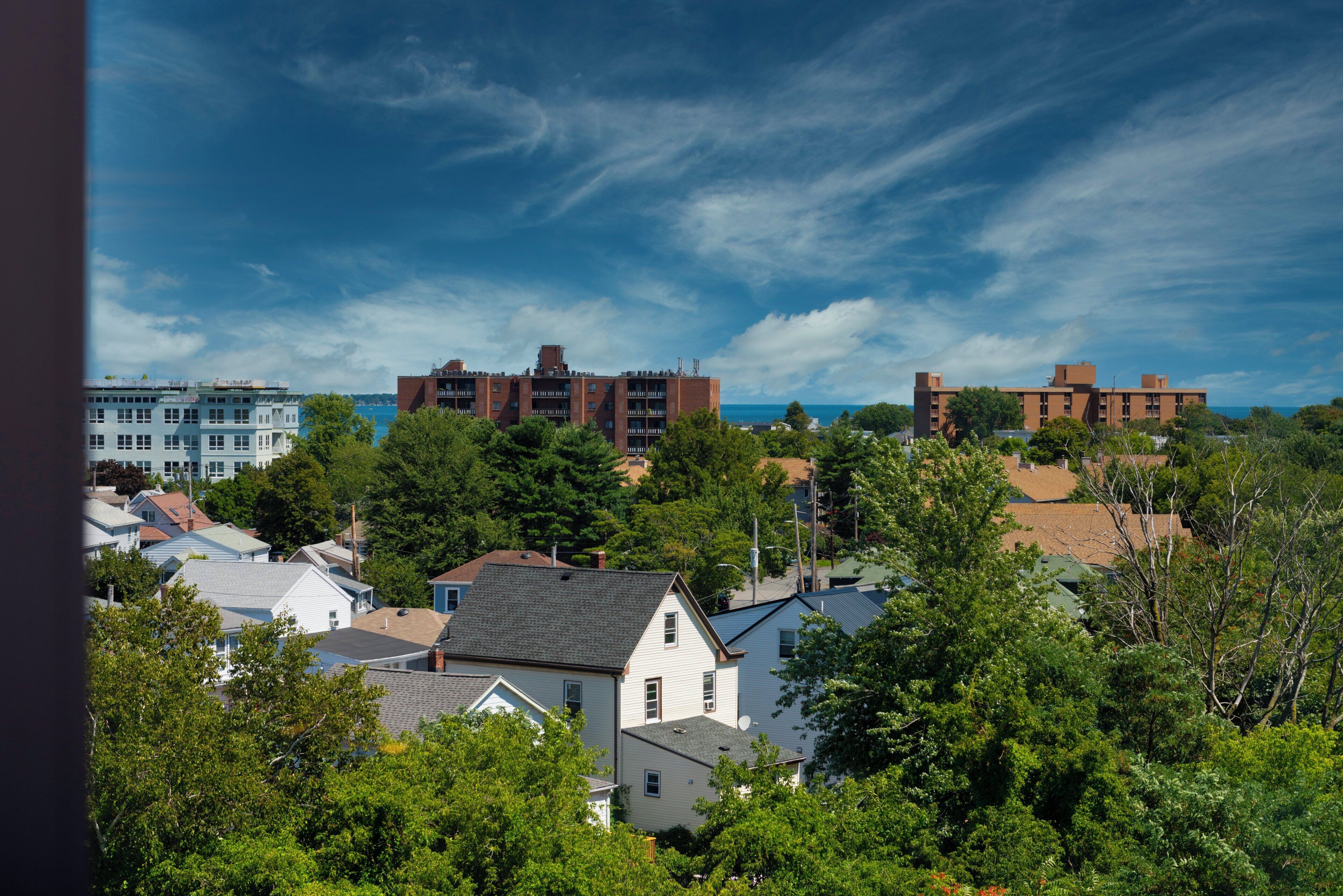 A residential area with houses and a large building complex in the background.