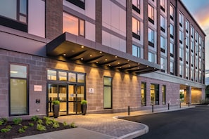 A hotel entrance with a covered walkway, large windows, and a sign indicating Staybridge Suites.