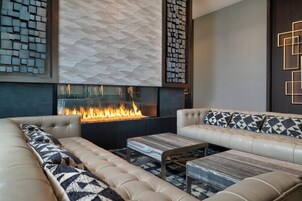 Una sala moderna con chimenea, sofás de cuero y cojines estampados.