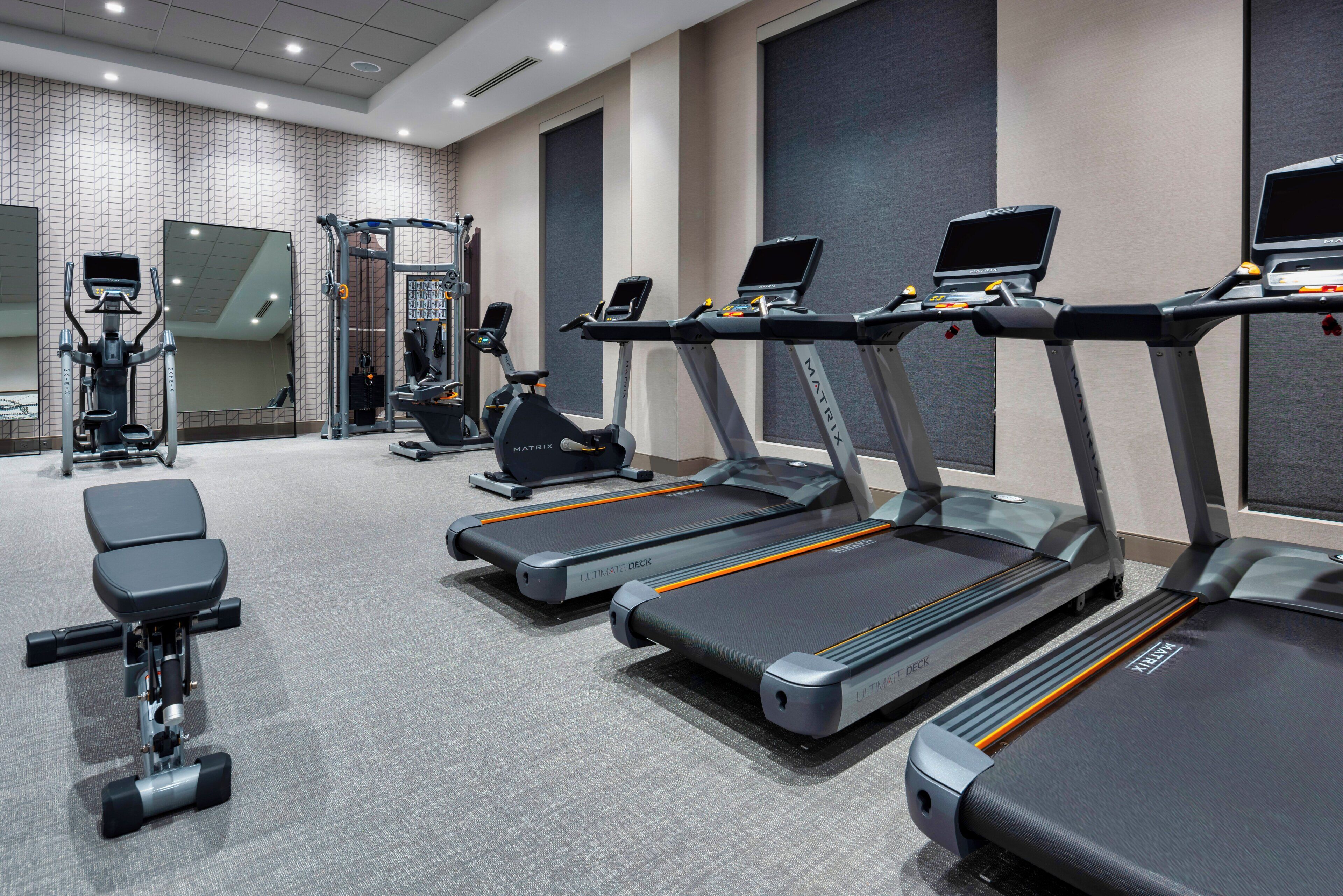 A gym with treadmills, a stationary bike, and weight machines.