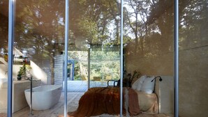 A modern bathroom with a large bathtub, a wooden floor, and a glass partition. - La Belle Folie (Ploemel)