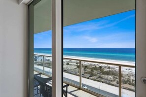 Ein Balkon mit Blick auf Strand und Meer.