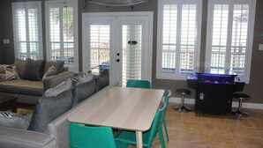 Een eethoek met een tafel en stoelen, een vis die aan de muur hangt, en een vissenkom.