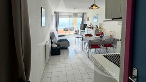 Hotellihuone, jossa on parveke, ruokailutila ja pieni keittiö.