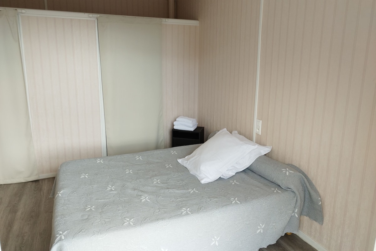 A bedroom with a bed, a nightstand, and a wardrobe.