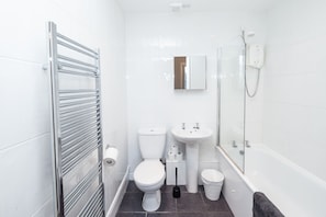 Bathroom features a pedestal sink, toilet, and glass-enclosed shower.