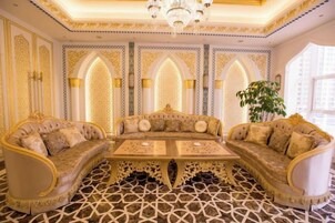 A luxurious room with ornate furniture, a chandelier, and intricate wall designs.