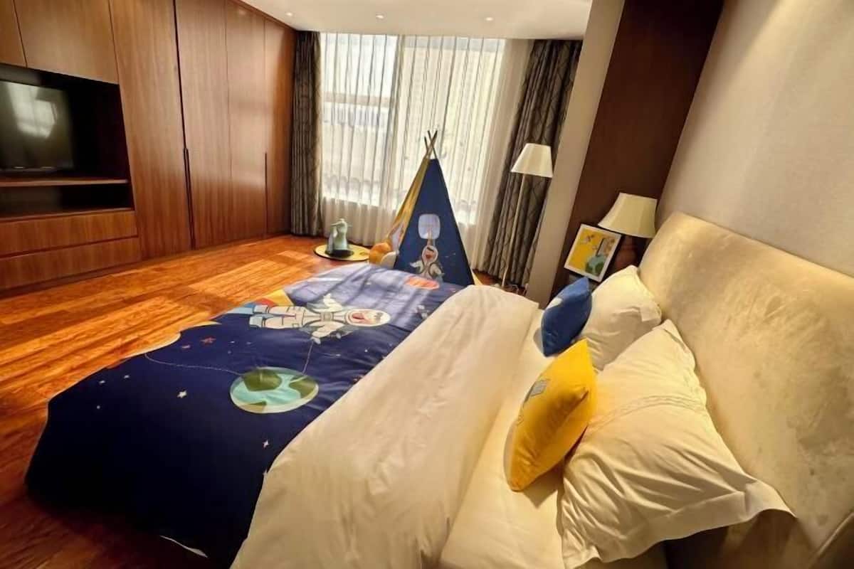 Een hotelkamer met een groot bed, een televisie, een tent en een lamp.