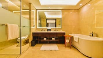 A modern bathroom with a glass shower enclosure, a freestanding bathtub, and a vanity with a large mirror.